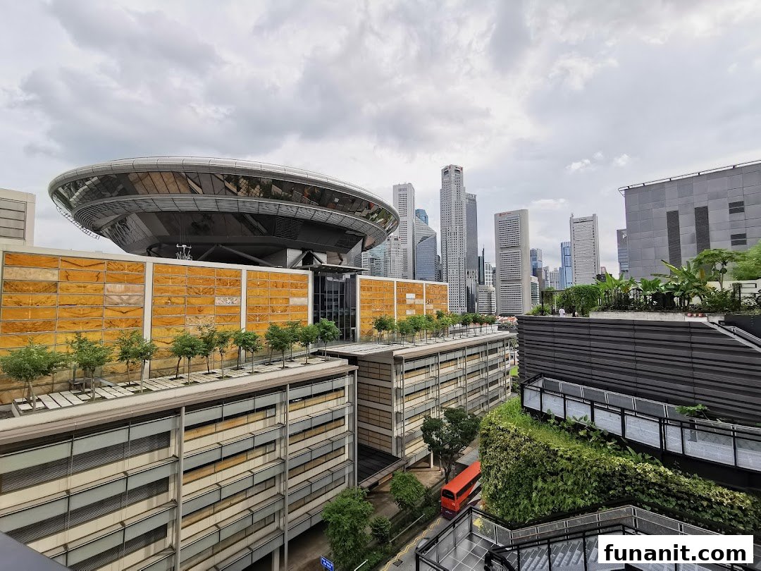 A panoramic view of a city skyline with modern buildings, a distinctive dome structure, and lush rooftop greenery.