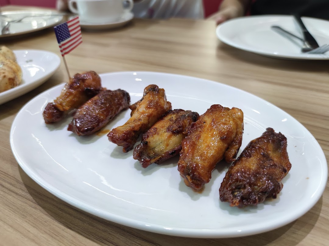 A plate of delicious golden-brown chicken wings with an American flag pick.