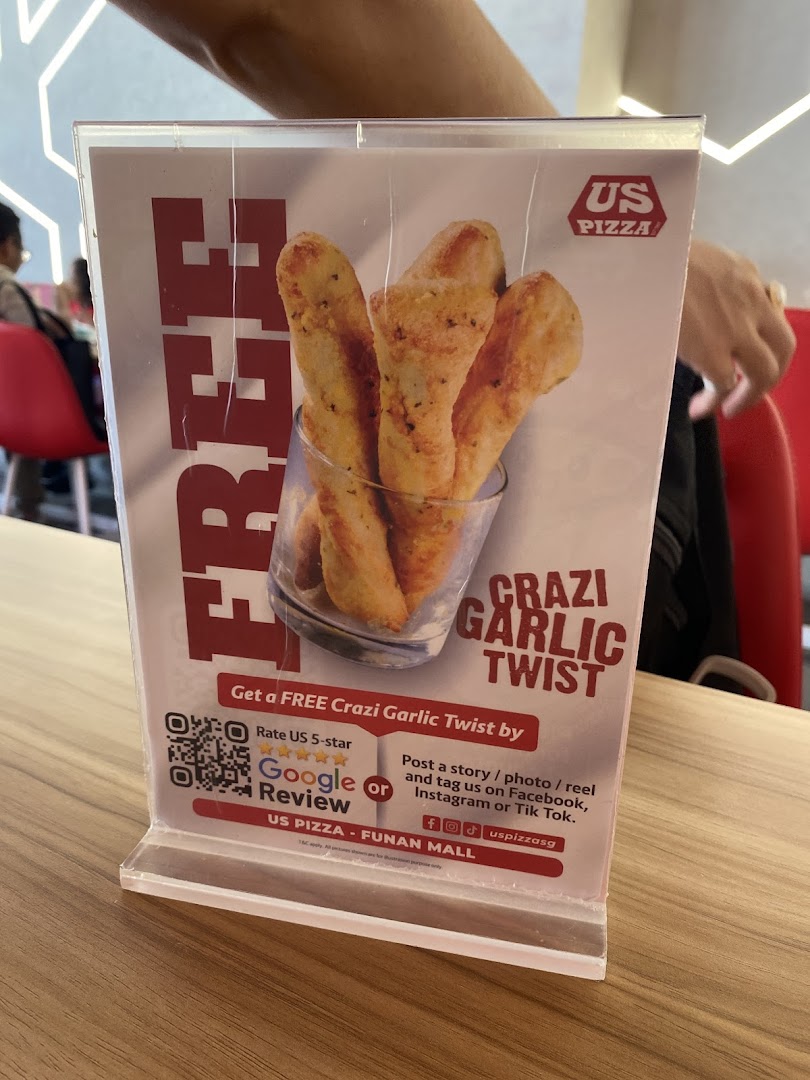 A table-top display promoting a free Crazi Garlic Twist at US Pizza Funan Mall.