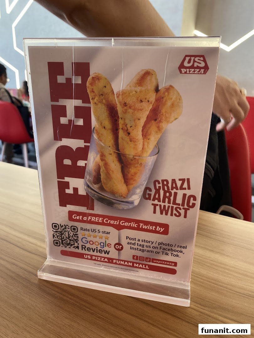 A table-top display promoting a free Crazi Garlic Twist at US Pizza Funan Mall.