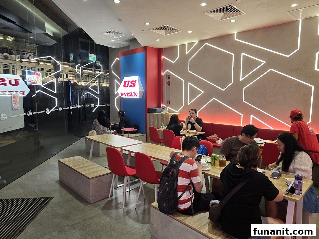 Diners enjoying meals inside US Pizza, featuring modern decor and comfortable seating.