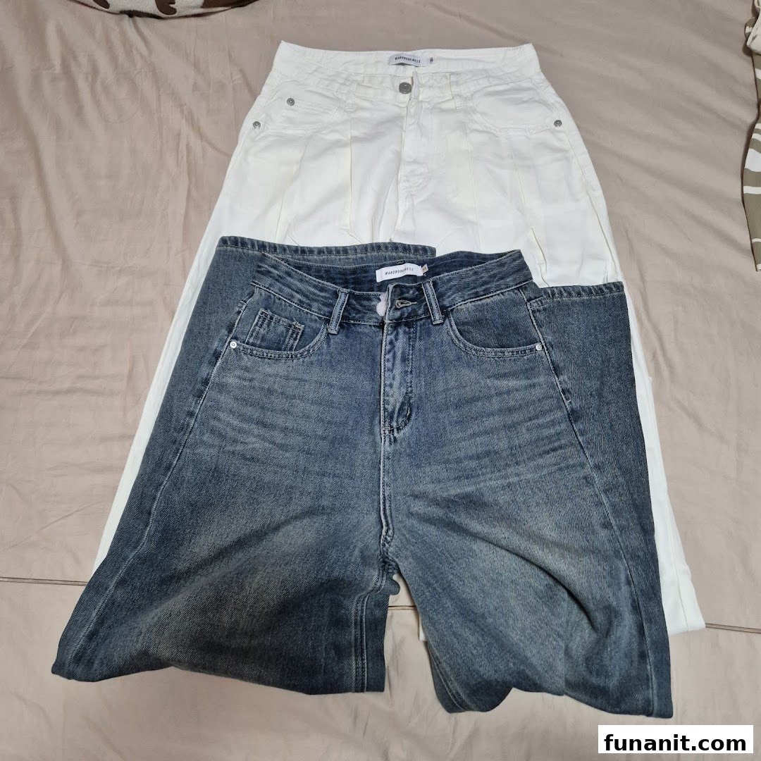 Two pairs of pants, one white and one blue denim, laid flat on a surface.