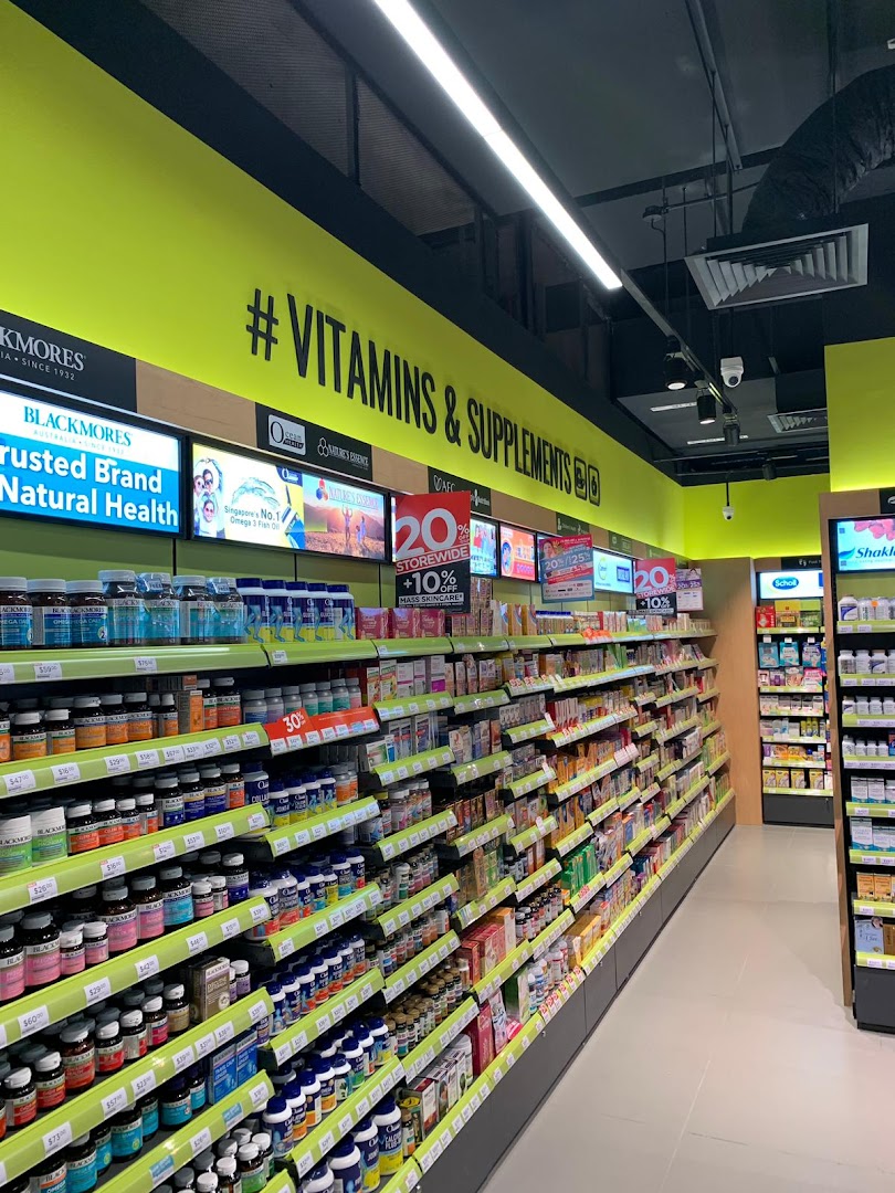 An aisle inside a Watsons/GNC store, brightly lit and stocked with a wide range of vitamins and supplements.