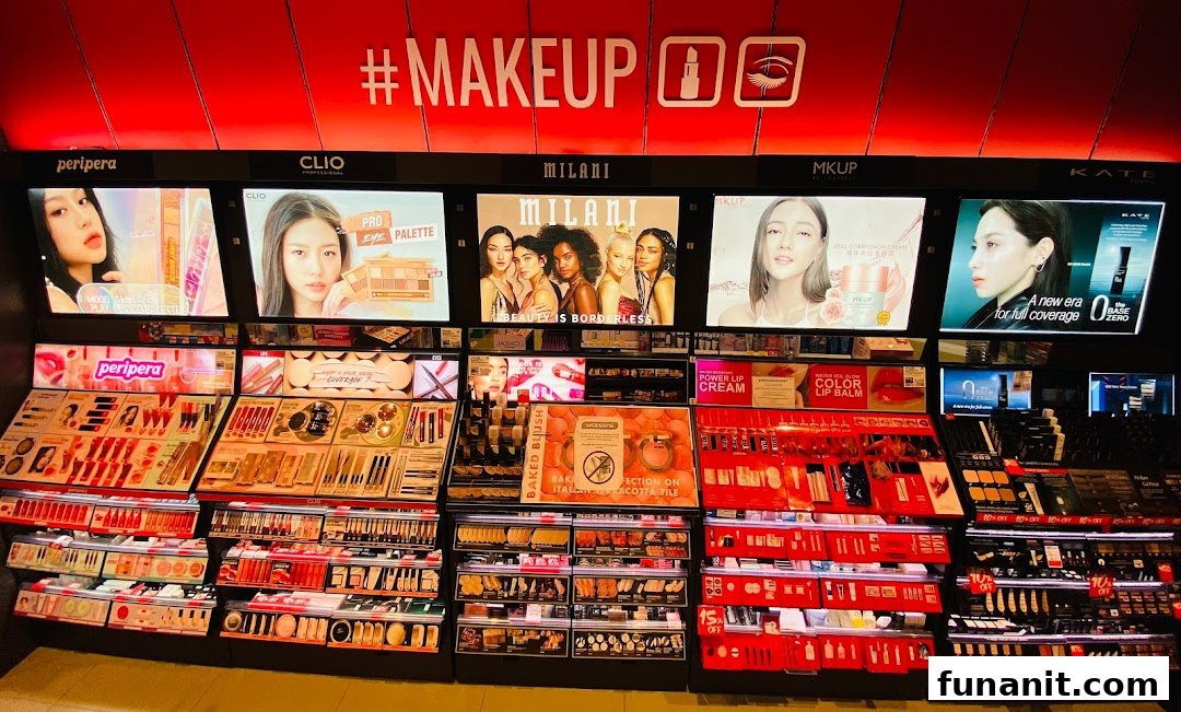 A vibrant display of makeup products from various brands like Peripera, Clio, Milani, and MKUP.