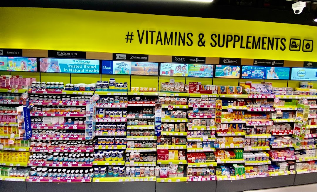 A well-stocked aisle featuring a wide array of vitamins and supplements at Watsons/GNC.