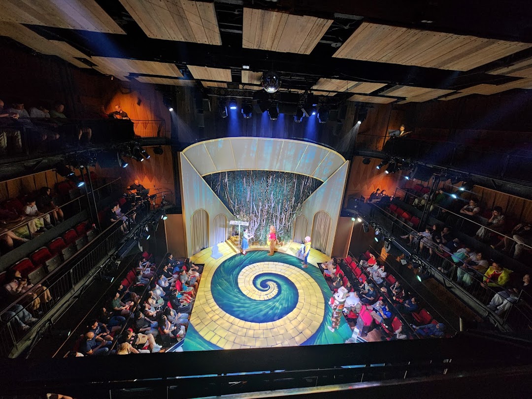 An aerial view of a vibrant theatre stage with performers and an audience at Wild Rice Funan.