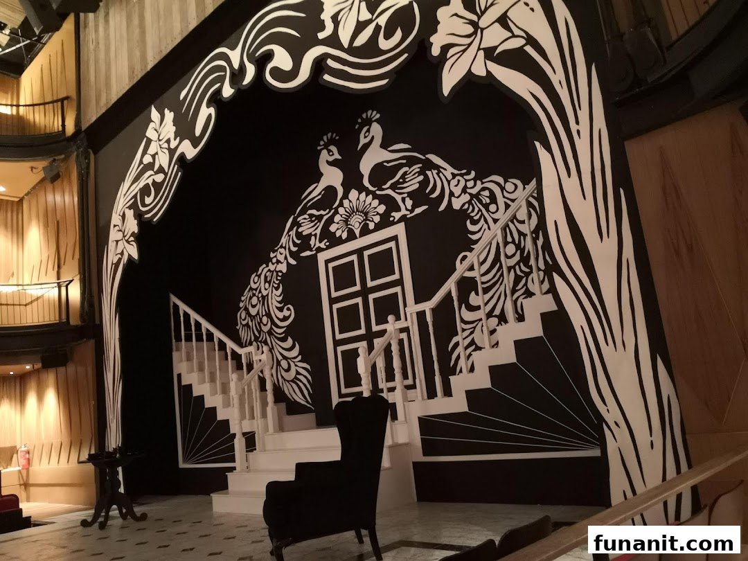 A striking black and white stage set featuring peacocks, a grand staircase, and ornate designs.
