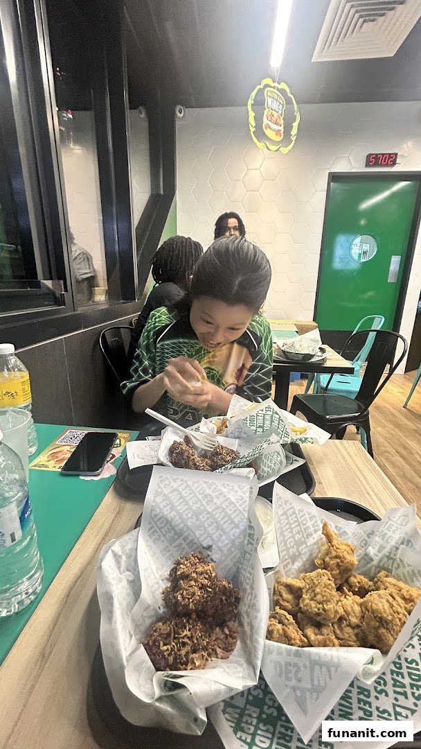 Customers enjoying various fried chicken items and drinks at Wingstop Funan, showcasing a lively dining experience.