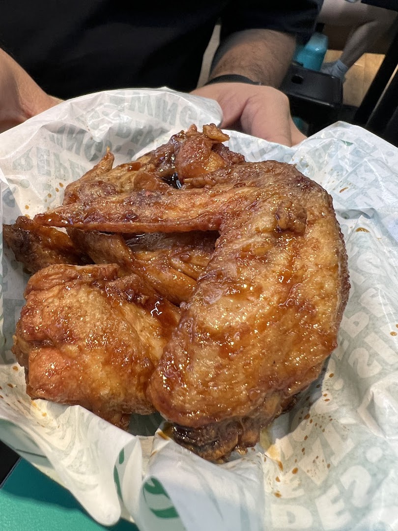 Delicious glazed chicken wings served in a paper liner, ready to be enjoyed.