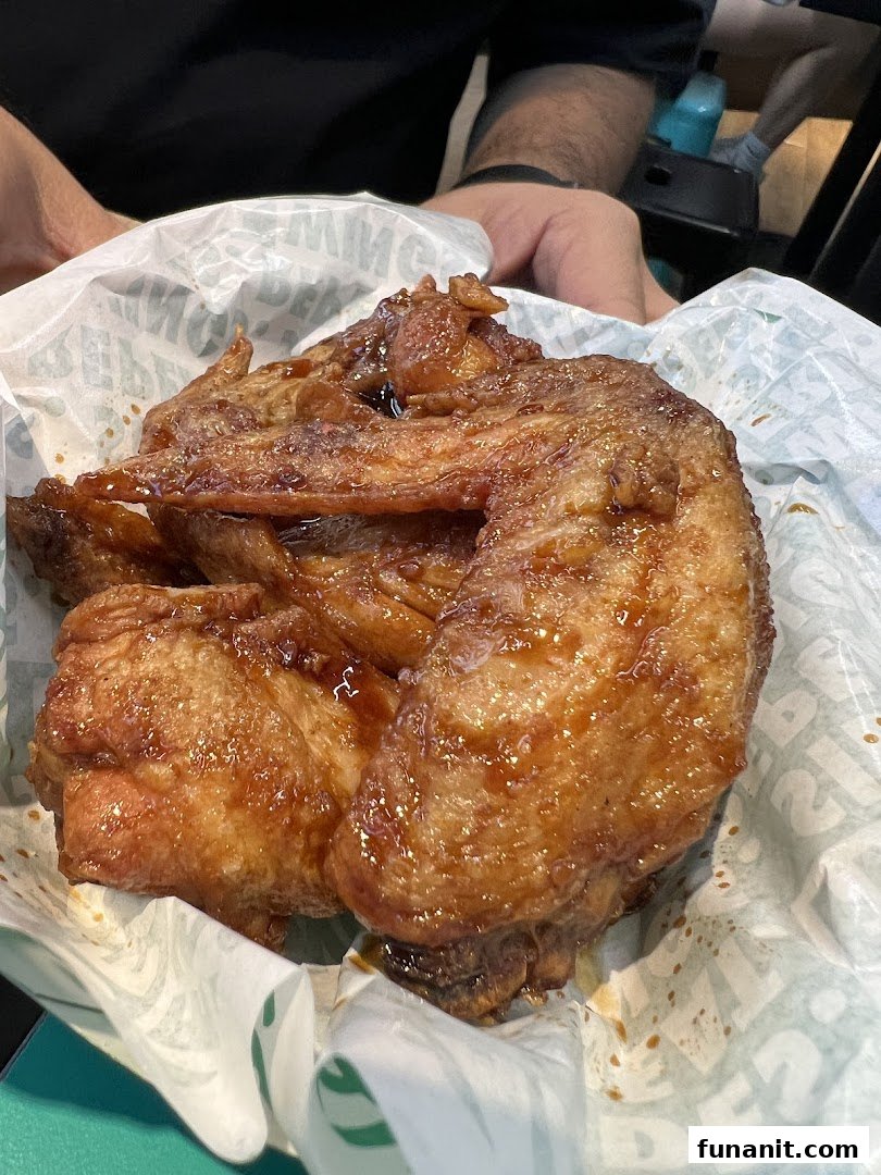 Delicious glazed chicken wings served in a paper liner, ready to be enjoyed.