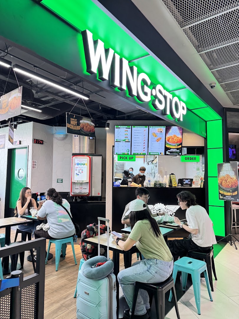 Customers enjoy delicious wings and sides at Wingstop Funan's vibrant, modern counter and dining area.