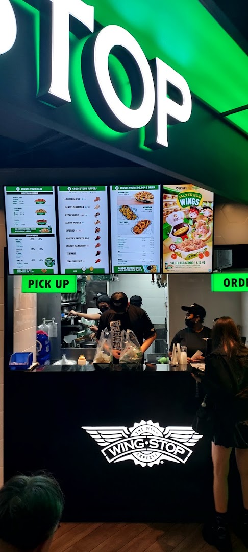 Interior view of Wingstop Funan showing the service counter, staff, and digital menu boards.