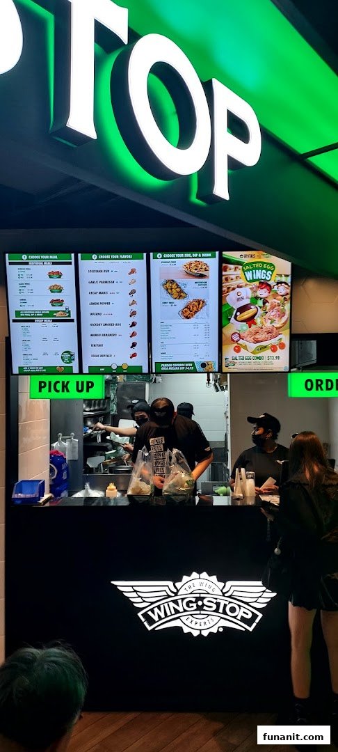 Interior view of Wingstop Funan showing the service counter, staff, and digital menu boards.