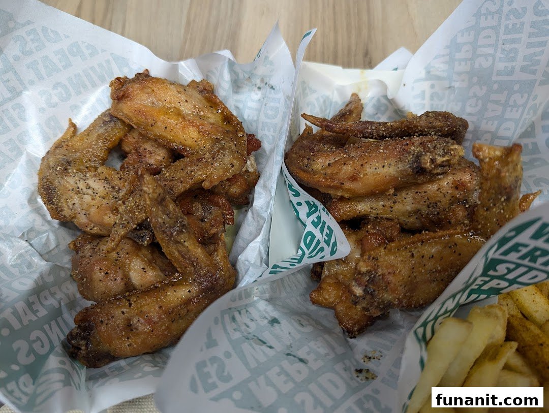 Close-up of delicious seasoned chicken wings and fries from Wingstop.