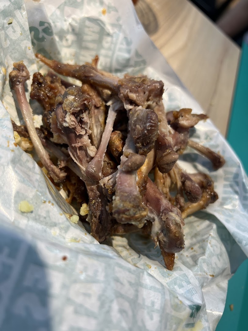 A pile of chicken wing bones in a Wingstop wrapper, showing the aftermath of a delicious meal.