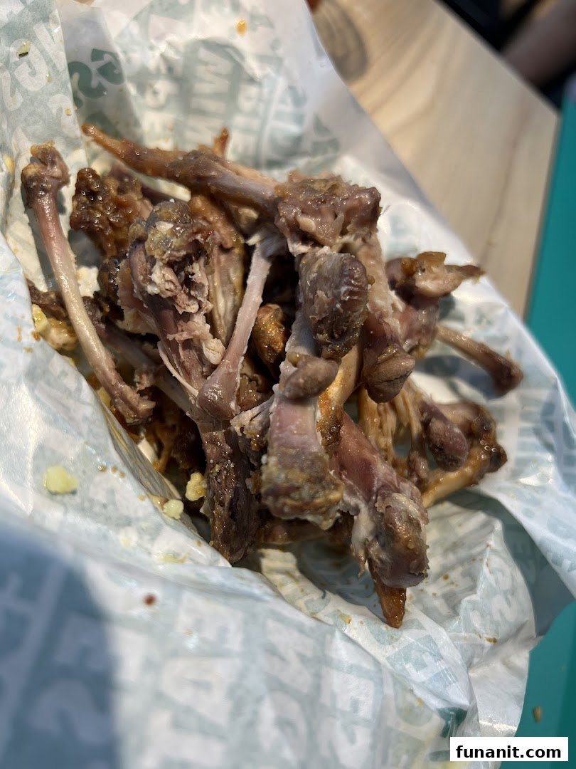 A pile of chicken wing bones in a Wingstop wrapper, showing the aftermath of a delicious meal.