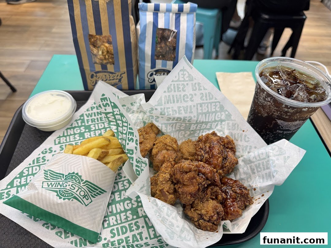A delicious Wingstop meal featuring crispy chicken, golden fries, a refreshing drink, and creamy dip.