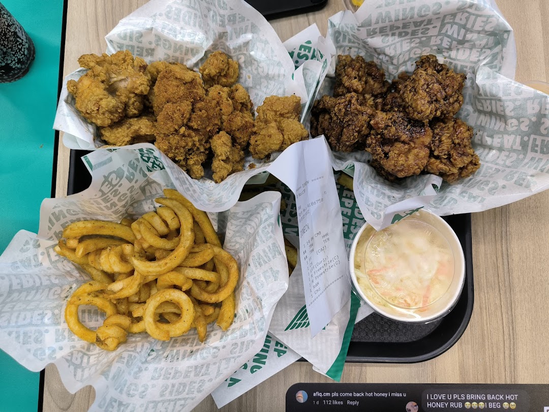 A delicious spread of Wingstop's crispy chicken, golden curly fries, and refreshing coleslaw on a tray.