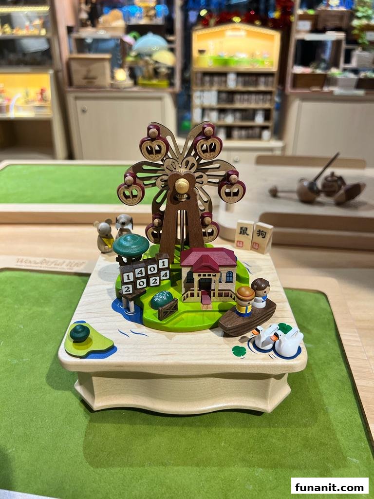 A detailed wooden music box featuring a Ferris wheel, house, and figures, displayed in a retail setting.
