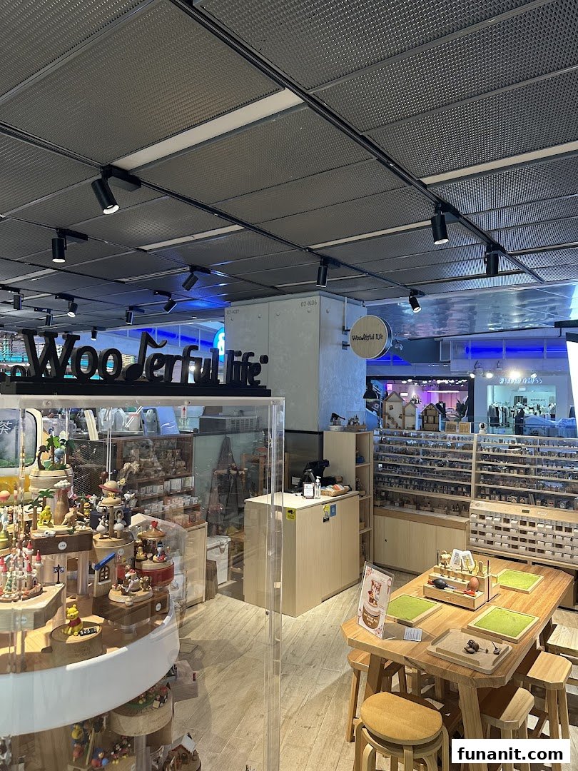 Interior view of Wooderful Life Singapore, showcasing intricate wooden music boxes, crafts, and a DIY workshop table.