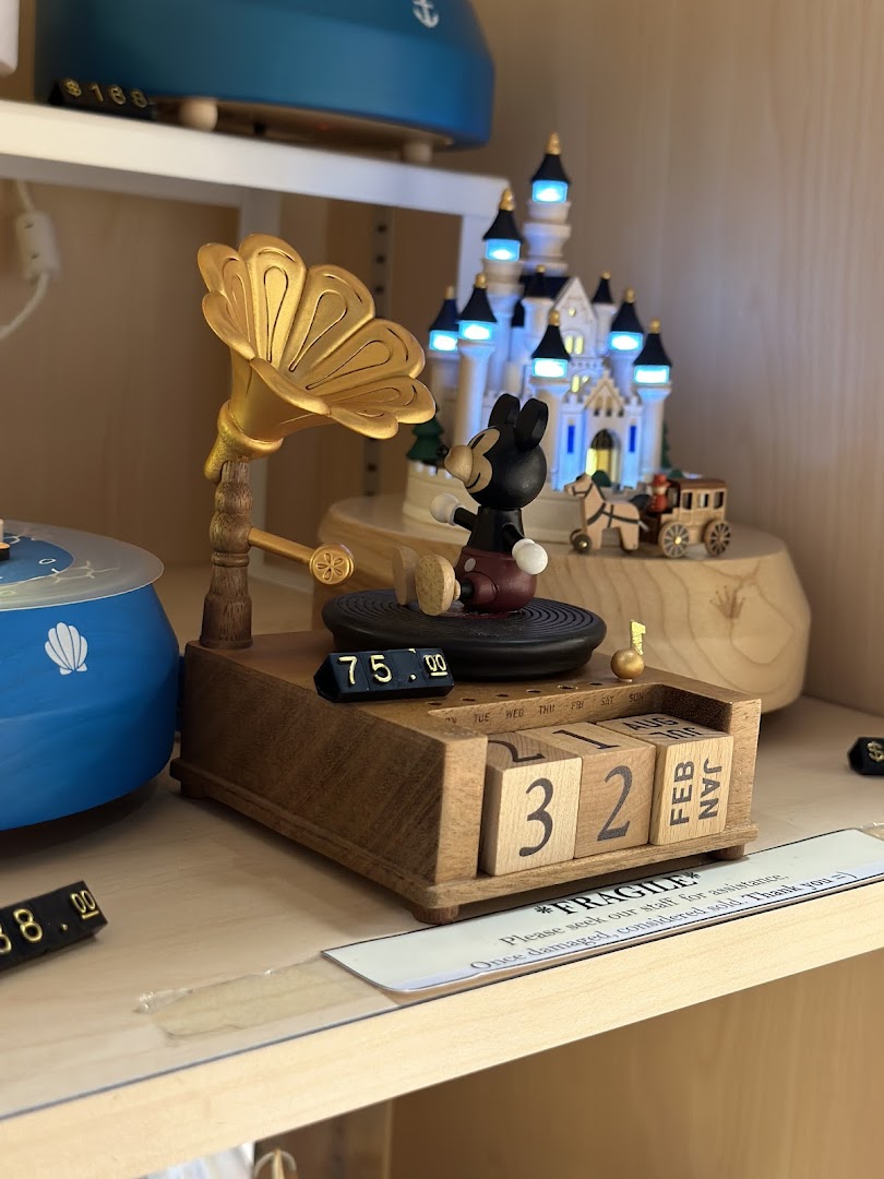 Close-up of a charming wooden Mickey Mouse music box with a gramophone and perpetual calendar.