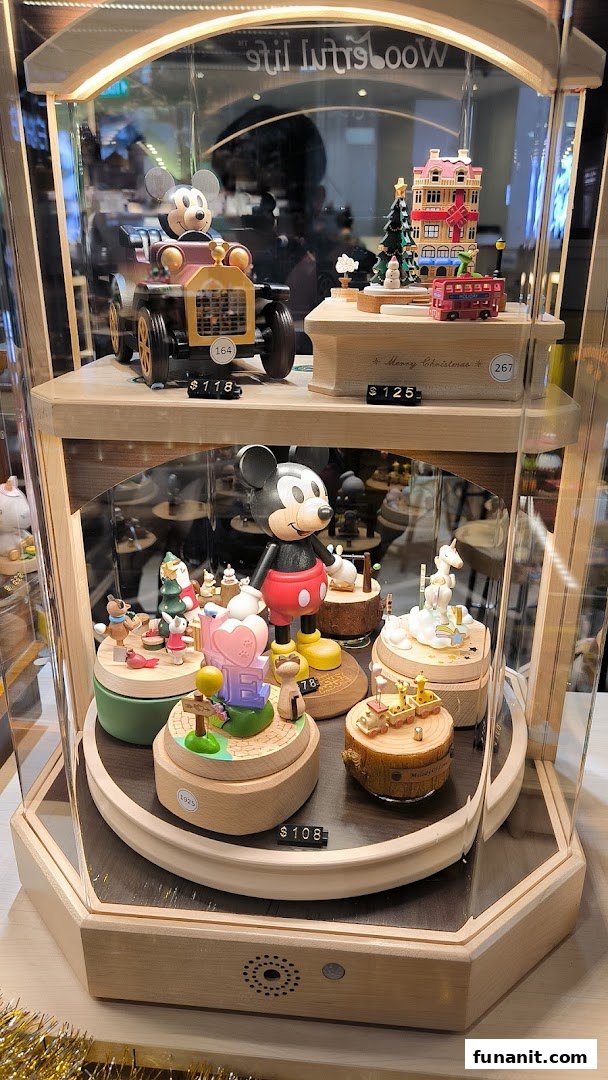A display case showcasing intricate wooden music boxes and figurines, including Disney characters, with prices visible.