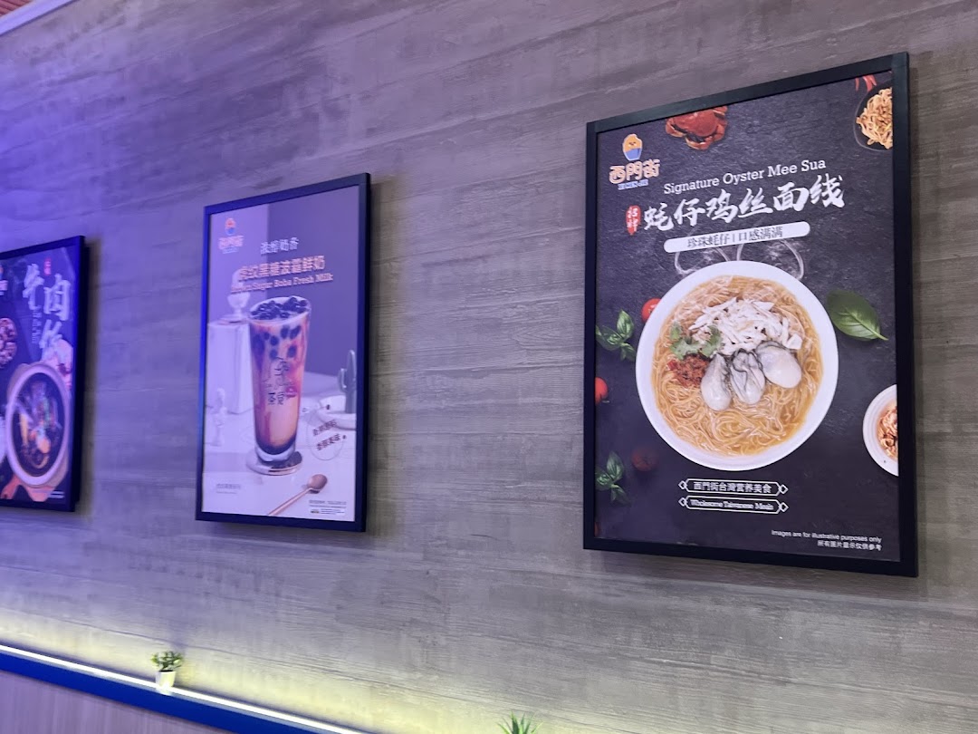 Promotional posters on a wall showcasing Signature Oyster Mee Sua and Brown Sugar Boba Fresh Milk.