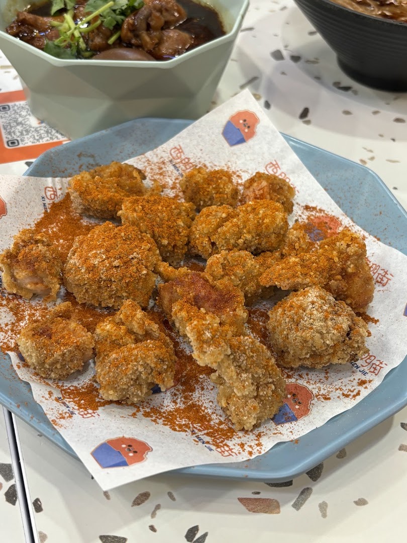 A plate of crispy Taiwanese fried chicken pieces generously seasoned with chili powder.