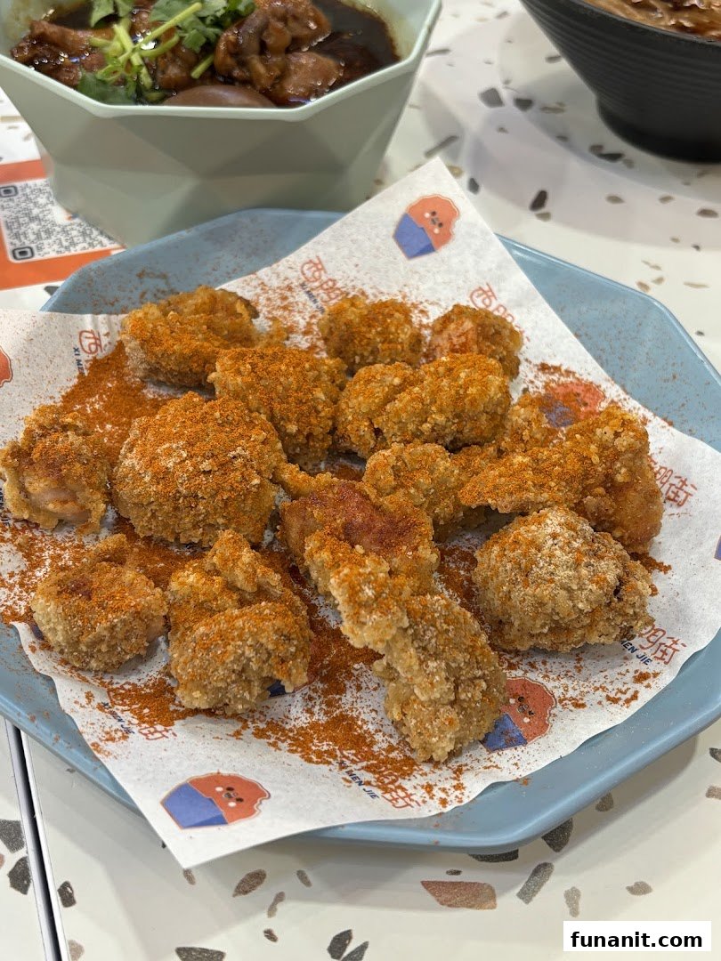 A plate of crispy Taiwanese fried chicken pieces generously seasoned with chili powder.