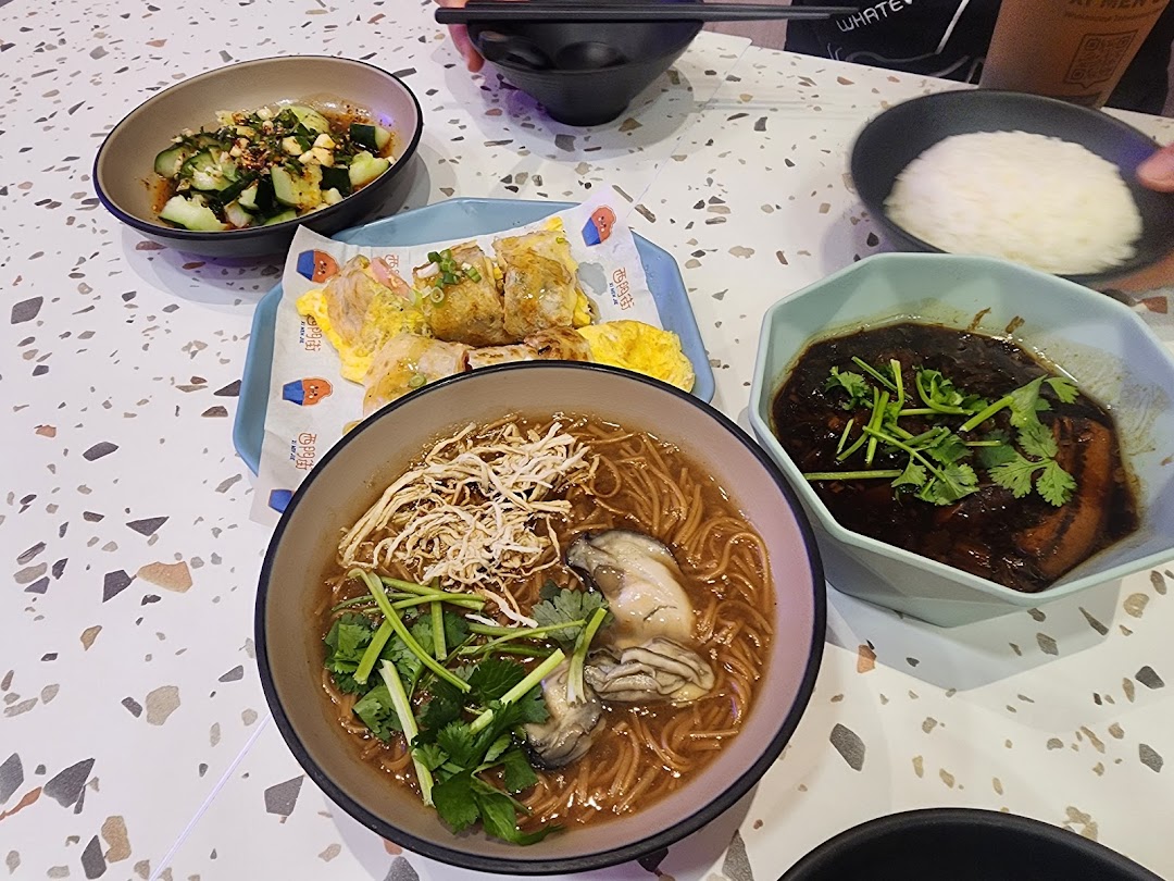 A table laden with delicious Taiwanese dishes, including oyster mee sua, braised pork, and refreshing cucumbers.