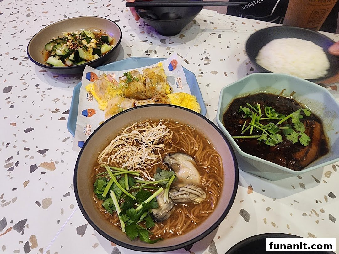 A table laden with delicious Taiwanese dishes, including oyster mee sua, braised pork, and refreshing cucumbers.
