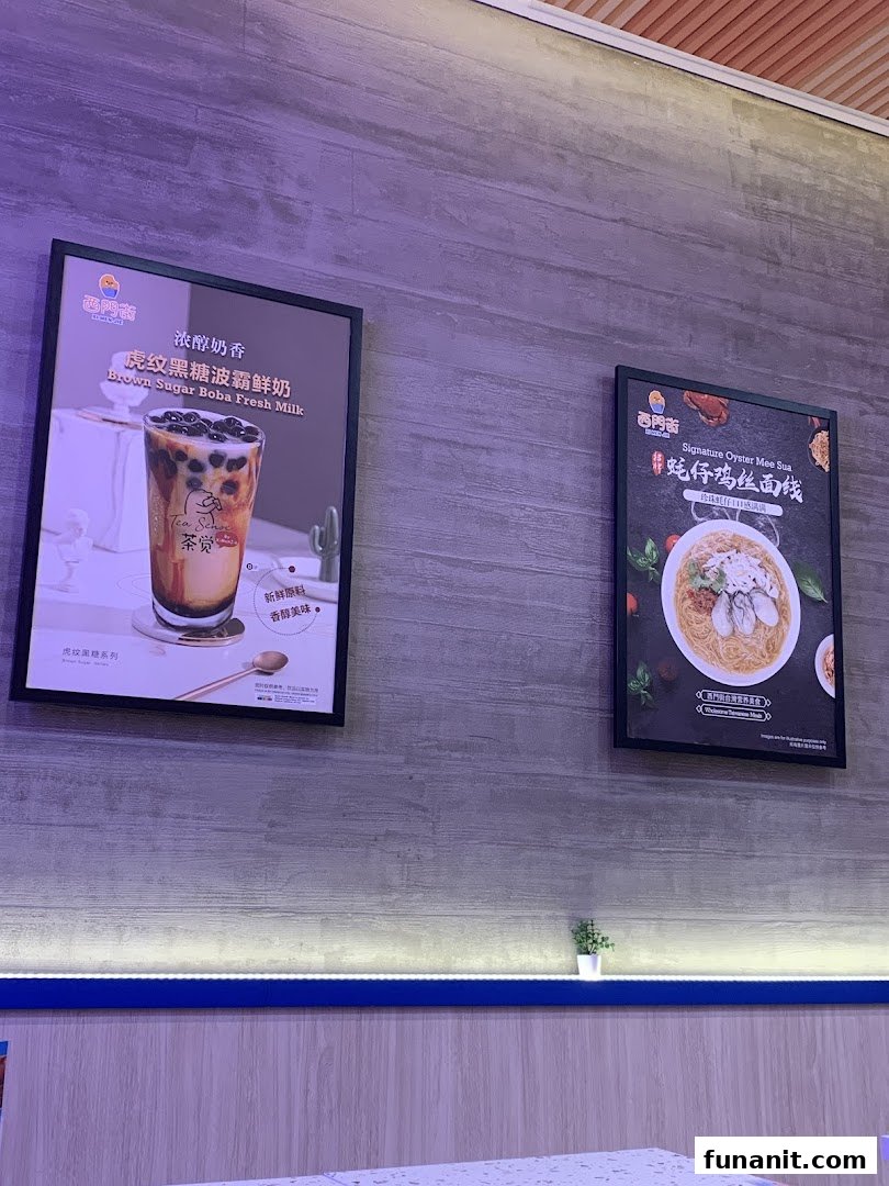 Two framed posters on a wall showcasing Brown Sugar Boba Fresh Milk and Signature Oyster Mee Sua.