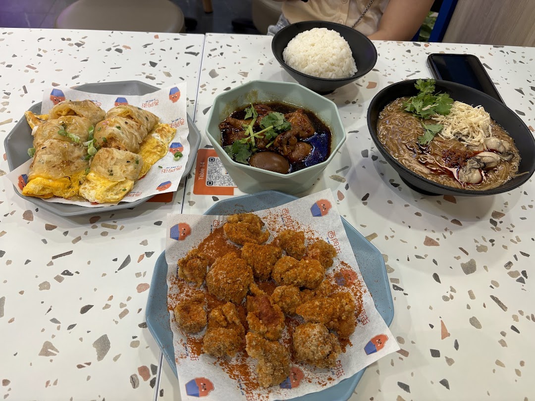 A table laden with delicious Taiwanese dishes including oyster mee sua, braised pork, fried chicken, and egg crepes.