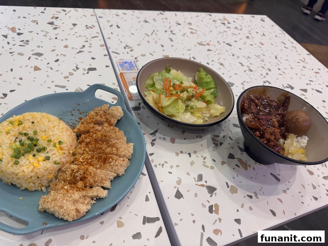 A delicious spread of Taiwanese fried chicken cutlet with fried rice, braised pork rice, and vegetables.