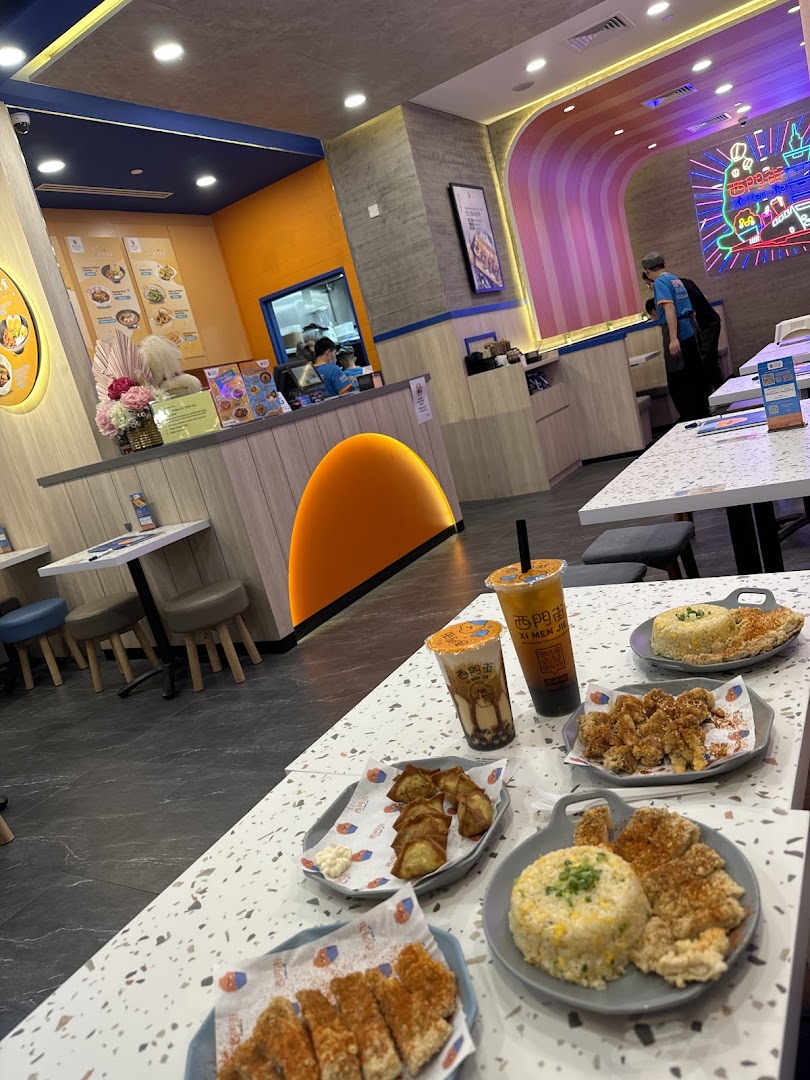 A vibrant interior shot of Xi Men Jie, showcasing delicious Taiwanese meals and bubble tea on tables.