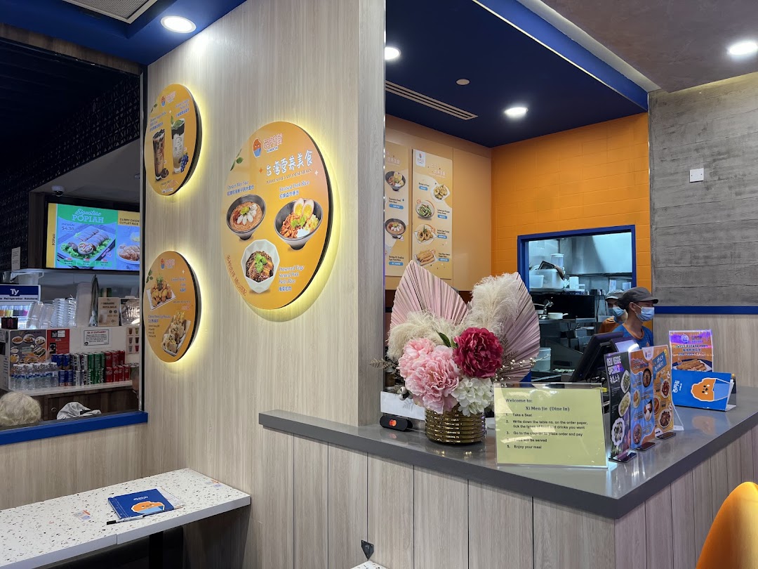 Interior view of Xi Men Jie, showcasing the counter, menu displays, and a staff member.