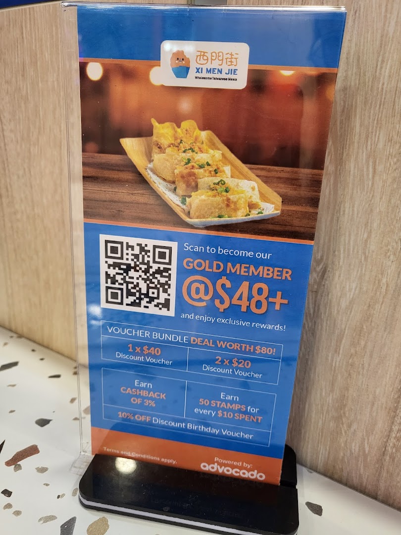 A promotional stand for Xi Men Jie's Gold Member program, showcasing membership benefits and delicious Taiwanese food.