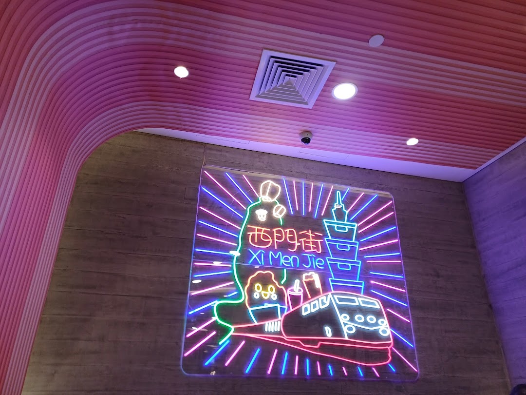 A vibrant neon sign featuring Taiwanese landmarks and a train, illuminating the shop's interior.
