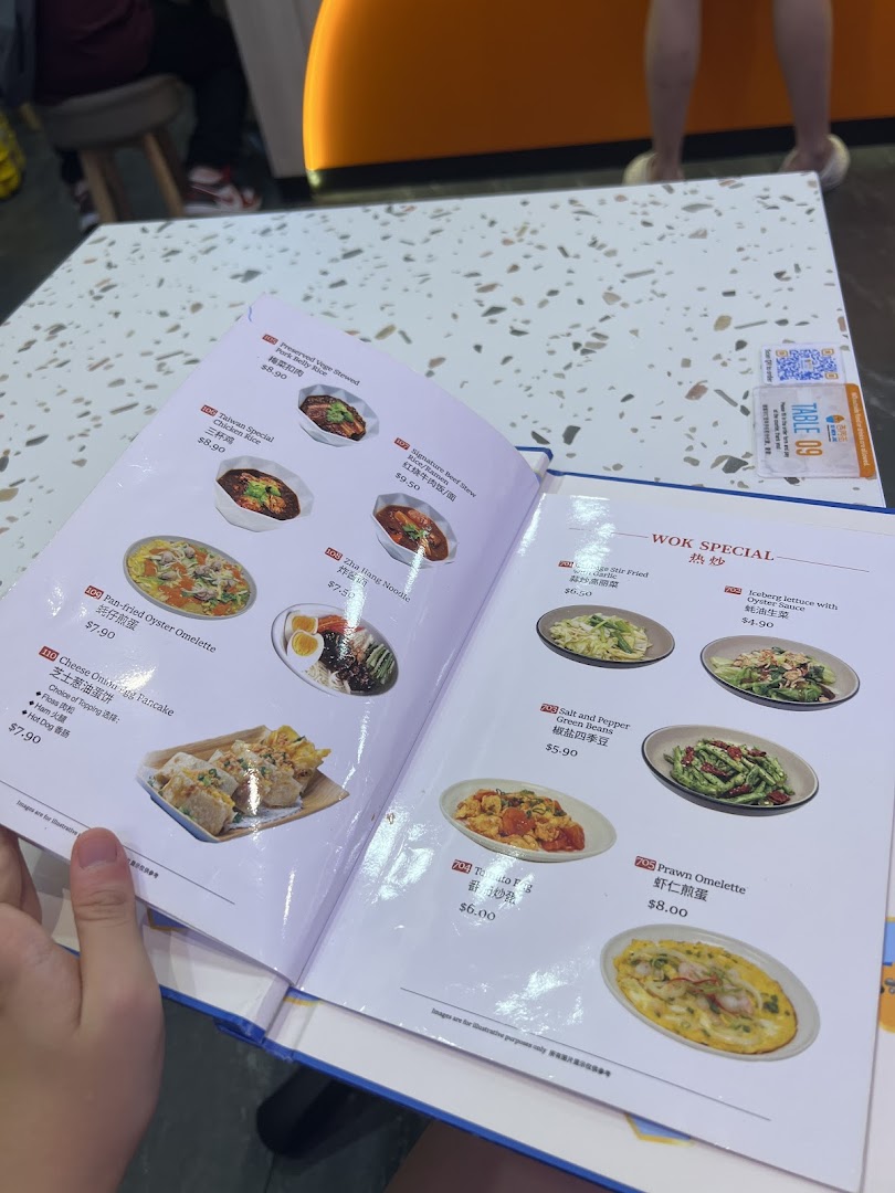 An open menu book displaying various Taiwanese dishes with photos and prices at Xi Men Jie.