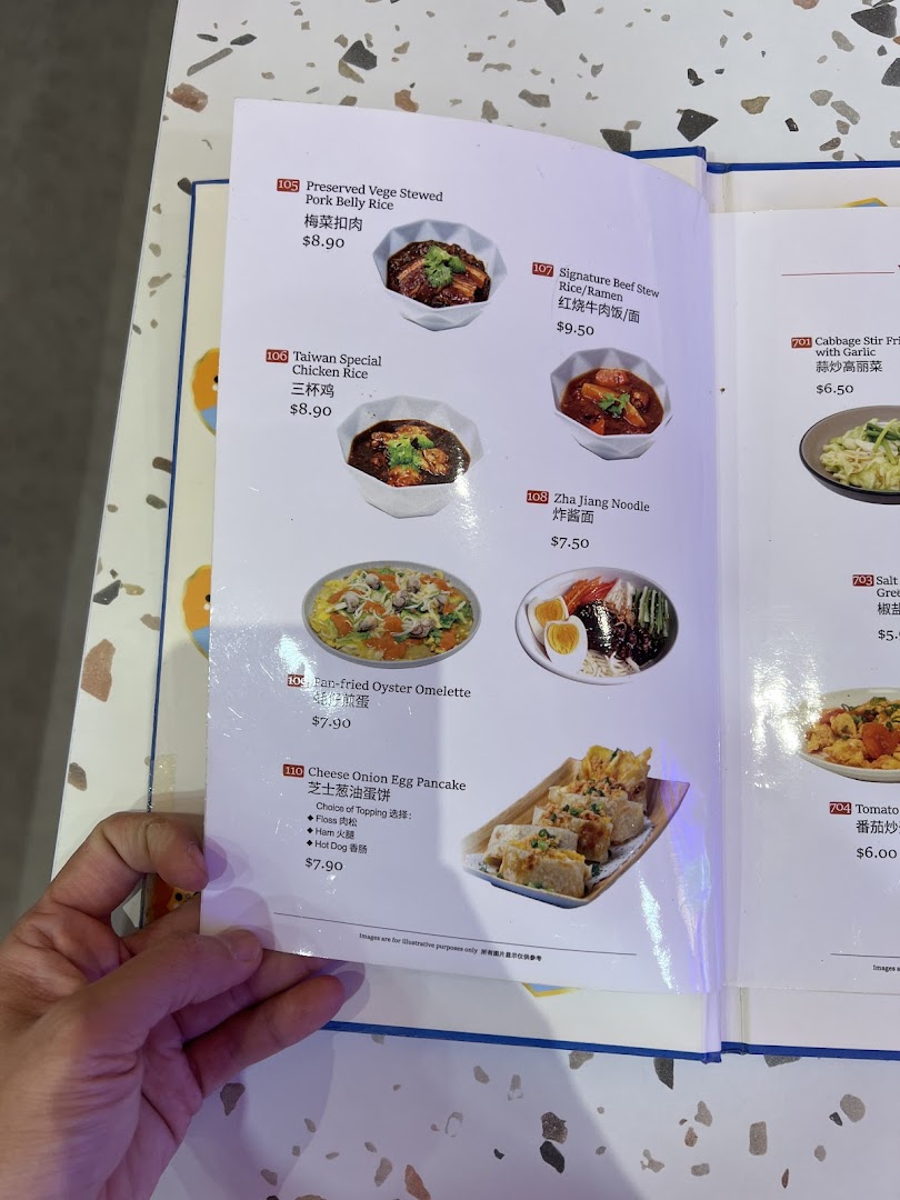 A close-up of a menu page from Xi Men Jie, showcasing various Taiwanese dishes with prices.