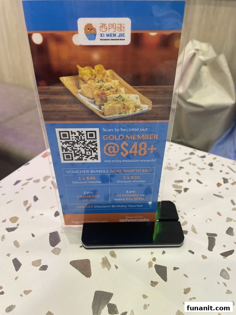 A standee promoting Xi Men Jie's Gold Member program with exclusive rewards and a food image.