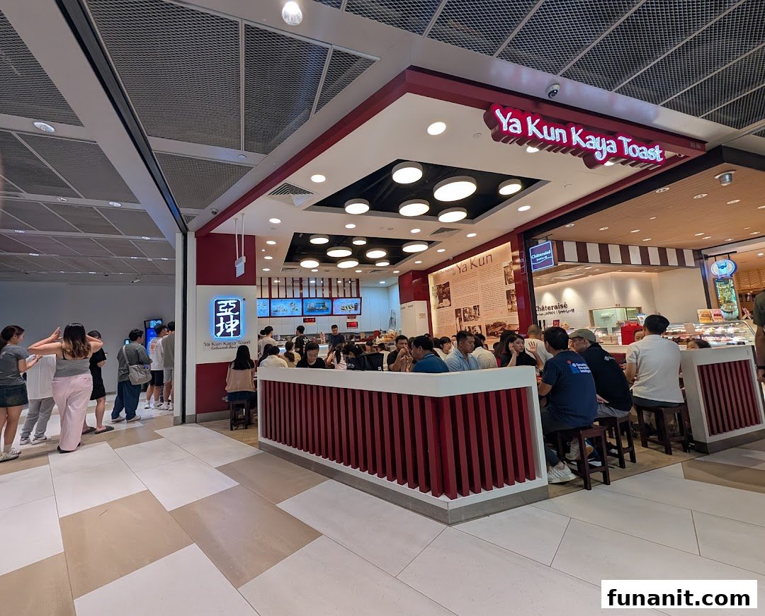 Customers enjoying traditional Singaporean breakfast and coffee inside a bustling Ya Kun Kaya Toast outlet.
