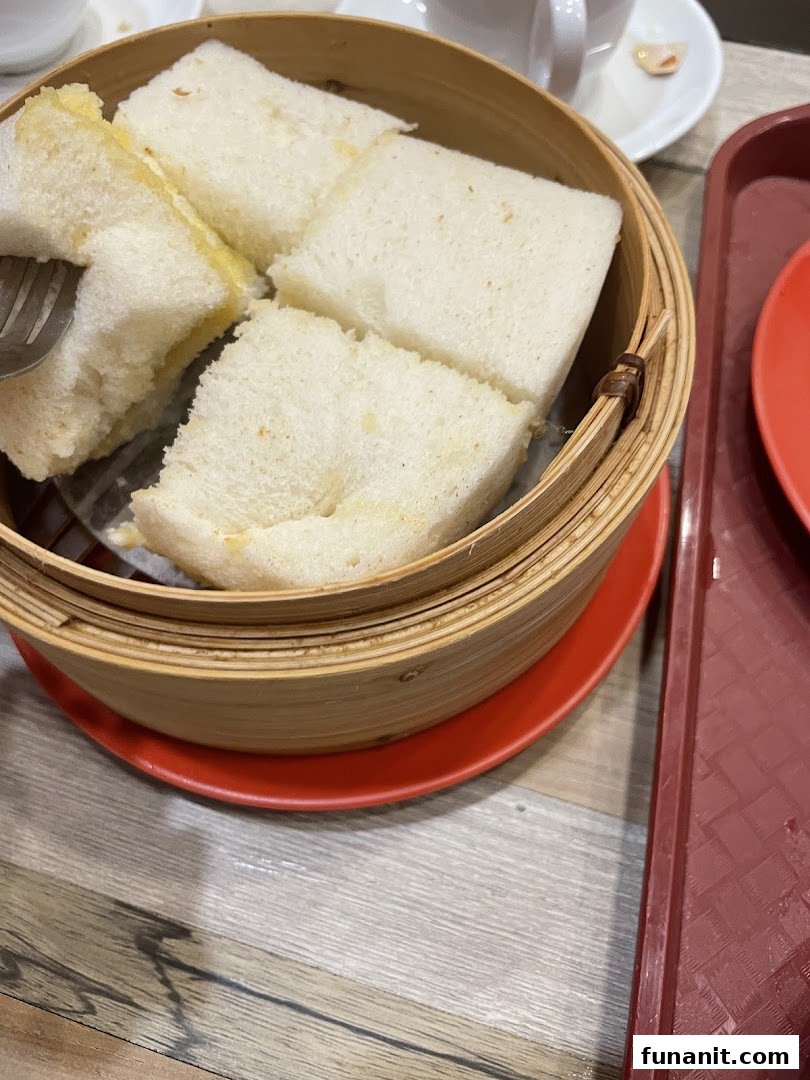 Close-up of fluffy steamed bread served in a traditional bamboo steamer at Ya Kun Kaya Toast.