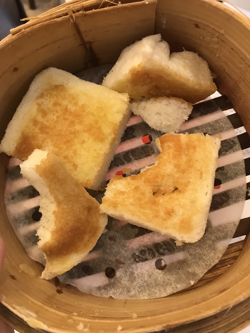 Close-up of golden-brown toast pieces served in a traditional bamboo steamer basket.