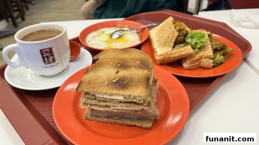 A tray featuring traditional Singaporean breakfast items: kaya toast, soft-boiled eggs, and coffee.