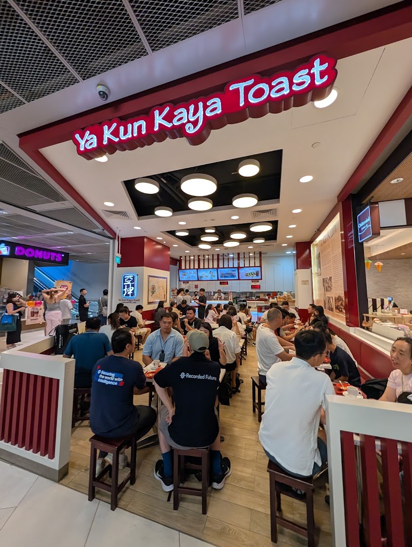 A bustling interior view of Ya Kun Kaya Toast, showing customers enjoying their meals in a vibrant setting.
