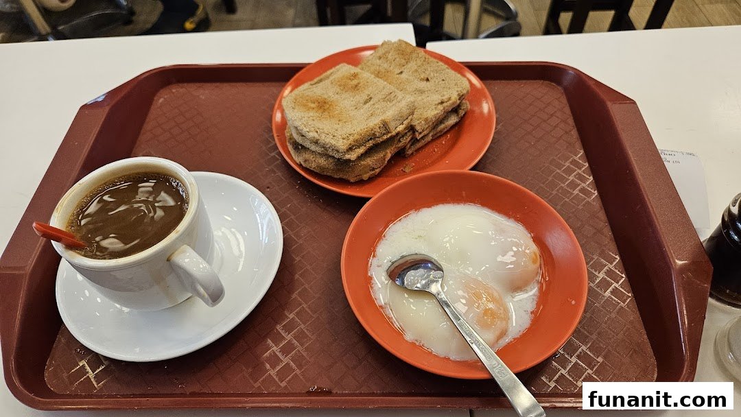 A traditional Singaporean breakfast set featuring kaya toast, soft-boiled eggs, and a cup of coffee.