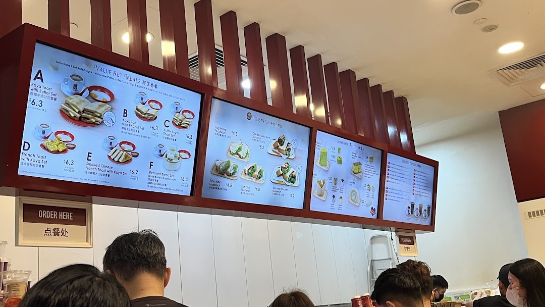 Digital menu boards at Ya Kun Kaya Toast displaying various breakfast sets, toastwiches, and pastries.
