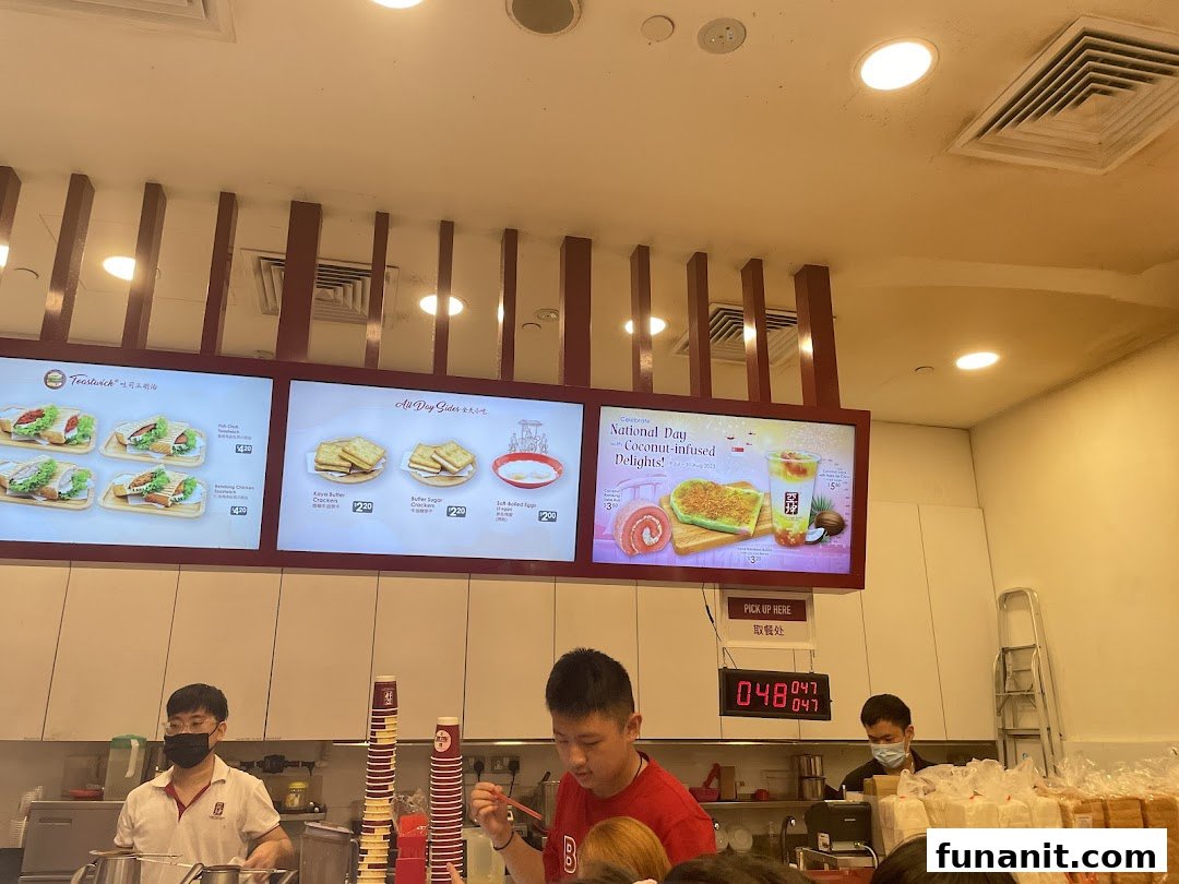 A bustling Ya Kun Kaya Toast counter showcasing various menu boards with toast, sides, and special drinks.