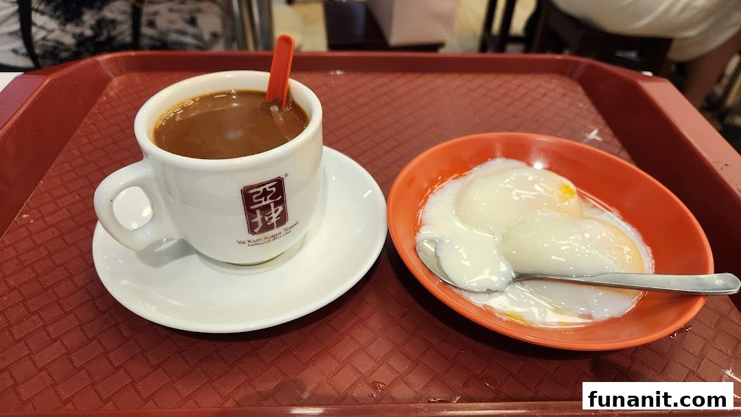 A traditional Singaporean breakfast set featuring a cup of coffee and soft-boiled eggs on a red tray.